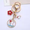 Lindo Conejo de Dibujos Animados Colgante Llavero de Aleación Flores Creativas Conejo Luna Etiqueta Accesorios Paquete de Auriculares