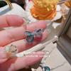 Pendientes de lazo de zafiro acuático luminoso brillante chapados en oro de 18 quilates con mariposa de circonita Caibao multifacética.