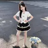 Top de manga corta estilo universitario 2026, moderno y único, falda de encaje dulce tipo pastel, nuevo conjunto de dos piezas de verano para niños mayores