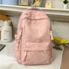 Mochila estilo universitário azul gelo claro com padrão escuro em formato de coração, com alças de ombro largas ajustáveis para alunos do ensino fundamental II e médio