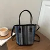 Bolso cubo tejido de paja de nicho al por mayor para mujer, nuevo estilo verano 2026, con bloques de color, bolso de hombro de lujo ligero, bolso cruzado versátil