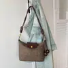 Bolsa de ombro de camurça vintage 2026 novo modelo, bolsa transversal versátil de nicho para o dia a dia com alça de ombro de corda torcida, bolsa de axila com toque de alta qualidade