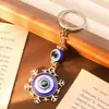 Llavero con diseño de ojos azules y brújula retro, colgante de copo de nieve y luna, con explosiones transfronterizas, accesorios para mochila.
