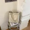 2026 nuevo bolso de cubo de mano hueco tallado de nicho estilo ins, moderno, casual, simple, de un solo hombro cruzado para mujer