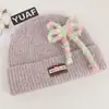 Gorro de punto estilo coreano de mezcla de lana inspirado en la dopamina con un lazo, un gorro de invierno cálido y protector para las orejas para mujer, adecuado para estudiantes