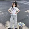 Nuevo estilo de verano para niños mayores, estilo universitario coreano, cuello polo, manga corta, a cuadros de moda, pantalones casuales de pierna ancha, conjunto de dos piezas