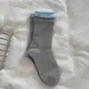 ¡Tan coreano! Es difícil resistirse a estos calcetines gris azulados con dulces lazos de cinta y botones, perfectos para otoño e invierno.