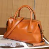 Bolsa de mão em couro genuíno, bolsa estilo bowling de nicho para mulheres, bolsa Boston almofadada moderna e versátil, bolsa transversal de design casual