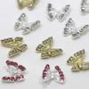 Brocas para uñas con forma de mariposa hueca de aleación con explosiones transfronterizas, venta al por mayor, con diamantes tridimensionales, adornos para uñas de metal dorado y plateado.