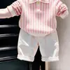 Ropa infantil coreana 2026 primavera y otoño nuevo conjunto de suéter de punto con cuello polo a rayas rosas y pantalones casuales blancos