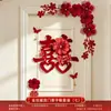 Nueva decoración de habitación de bodas estilo chino, con caracteres auspiciosos, decoraciones festivas para puertas, borlas y arreglos florales, creando un telón de fondo pintoresco para las fotos de boda.