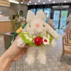 Novo Chaveiro de Coelho de Orelhas Longas Pelúcia Vestido Fofo e Fofo Segurando Flores Boneca Coelho Pingente de Bolsa para Mulheres