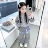 Conjunto Informal de Moda para Niñas para Primavera y Otoño: Conjunto de Dos Piezas con Top de Manga Larga Estampado a Cuadros tipo Patchwork Falso con Falda y Pantalones de Pierna Ancha