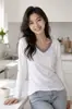 Suministrado directamente por la fábrica de ropa de origen, top versátil de retazos para mujer de talla grande de otoño con manga larga y cuello en V, disponible para pedidos personalizados con sus propios diseños o muestras.