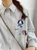 Camisa feminina listrada estilo japonês com bordado de desenho animado, modelagem solta e gola dobrável, coleção outono 2025.