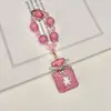 Pingente de chaveiro de garrafa de perfume com laço adornado com diamantes com corrente de contas de cristal, acessório de bolsa requintado e brilhante com diamantes, corrente para pendurar no celular