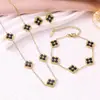 Conjunto de tres piezas de la suerte estilo europeo y americano: conjunto vintage de collar, aretes y pulsera de trébol de cuatro hojas en negro y dorado. Accesorios versátiles para el trayecto al trabajo al por mayor