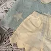 Ropa Infantil Estilo Coreano 2026 Nuevo Verano Conjunto de Dos Piezas para Niñas: Top a Cuadros con Cuello de Muñeca y Shorts con Dobladillo Ondulado