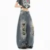 Calça jeans americana retrô com aspecto desgastado, salpicos de tinta e detalhes rasgados, nova coleção de primavera para mulheres, apresentando um design moderno e ousado com estampas de letras e estilo comprimento total.