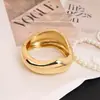 Pulsera personalizada de aleación irregular Pulsera transfronteriza europea y americana Pulsera de versión ancha de superficie brillante de lujo ligero con resorte
