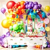 Decoraciones para fiesta de cumpleaños infantil con temática de arcoíris, que incluyen platos de papel desechables, pancartas, banderines y artículos decorativos
