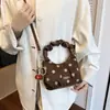 Bolsa de trabalho elegante e minimalista para mulheres, nova coleção 2026, apresentando um design texturizado e casual de bolinhas, uma bolsa de mão de alta qualidade e uma bolsa versátil de ombro ou transversal.
