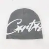 Chapéu de Tricô Jacquard Outono e Inverno Americano para Homens e Mulheres com Letras, Proteção Quente para as Orelhas, Gorro de Inverno Pulôver, Chapéu de Lã Versátil Hip-Hop de Rua