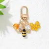 Bestseller transfronterizo: Llavero de aleación con recubrimiento de esmalte con diseño de abeja y panal incrustado con diamantes, llavero de dibujos animados, funda para auriculares, accesorio para bolso