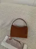 Bolso de mano de gamuza tejido a mano 2026, con un diseño único, un estilo bandolera minimalista y una correa de hombro de cuero genuino adecuada para el trabajo.