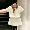 Conjunto de punto blanco fino de verano 2026 para niñas estilo coreano, falda de manga corta tipo Polo retorcido para bebé
