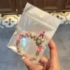 Libro Caperucita Roja Mismo Estilo Estudiante Pulsera de Glaseado de Palomitas de Maíz Hecha a Mano con Cuentas Dibujos Animados Cristal Pulsera Infantil Venta al por Mayor Cajas de Regalo