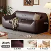 Sofá de estilo de mediados de siglo, color blanco roto, de piel sintética, con reposabrazos redondeados de forma única, cojines de asiento segmentados y diseño de pie, adecuado para una sala de estar como sofá de línea recta