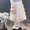 Conjunto de três peças moderno para mulheres de meia-idade: camisa colete inspirada na dopamina sobreposta a uma saia em camadas de retalhos de renda estilo coreano