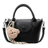 Otoño 2026 Nuevo Bolso Cuadrado Pequeño con Patrón de Lichi Estilo Coreano para Mujer Bolso Cruzado Versátil Bolso de Hombro para Viaje con Colgante de Oso de Peluche