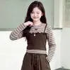 Conjunto de otoño para niñas 2026 nuevo modelo conjunto de dos piezas de imitación con top de retazos a rayas y pantalones cargo para niños venta al por mayor