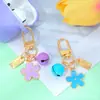 Llavero de Metal Pequeña Flor Estilo Ins con Goteo de Aceite Doble Cara con Etiqueta Pequeña y Cascabel Colgante para Bolsa de Auriculares de Niñas