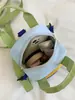 Colección de otoño 2026 transfronteriza: una mochila linda con estampado de dibujos animados, patchwork y bloques de color que se puede llevar como bolso de hombro o como mochila