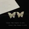 Pendientes de botón de perla y mariposa estilo INS de lujo ligero para mujer, versátiles, elegantes, de alta gama, personalizados, dulces y geniales, exquisitas joyas para la oreja, modernos~