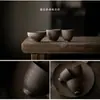 Juego de té de cerámica gruesa vidriada con detalles dorados, que incluye un cuenco con tapa de cerámica, una taza de té, una tetera con asa lateral y una taza de maestro, así como un cuenco para matcha