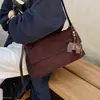 Elegante bolso de hombro nuevo de gamuza para mujer 2026 para ir al trabajo, estilo coreano, con un delicado charm de elefante, perfecto para otoño, se puede llevar en la mano o usar como bolso de hombro