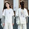 Camiseta de manga larga tipo dos piezas de imitación para niños, colección otoño 2026, para niñas, 100% algodón, cuello redondo, corte holgado, diseño lindo de caricatura, top básico