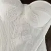 Elegante top de renda patchwork com detalhe de laço, cintura ajustada e efeito emagrecedor, tornando-o uma peça versátil