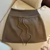 Foto real de saia vintage de camurça com cordão para mulheres, outono de 2026, cintura alta, justa ao corpo, curta