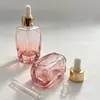 Botella de vidrio con corte facetado degradado Anillo dorado Cabezal de aplicador blanco Botella de empaque para aceite esencial para el cuidado de la piel Botella para aceite esencial para el cuidado de la piel