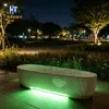 Fábrica de bancos ovalados de UHPC con terrazo translúcido para parques, céspedes, asientos de ocio para paisajes exteriores con emisión de luz verde