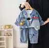 Otoño 2026 Estilo Coreano Ropa Exterior para Niños Caricatura Mezclilla Cuello Campana Primavera Manga Larga Ropa Elegante Conjunto de Tres Piezas Venta al por Mayor