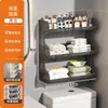 Baño de estilo abierto con un inodoro, un soporte para pañuelos de papel y toallitas húmedas encima del inodoro, y un estante de pared para toallas perfumadas