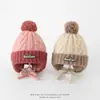 Gorro de punto con bloques de color para niños para otoño e invierno, con protección para las orejas y pompón grande, gorro de lana tipo Boston para niños y niñas
