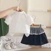 Nuevo atuendo de verano 2026 para niñas: conjunto elegante de manga corta con cuello, que presenta una camisa de dibujos animados y una falda corta, disponible para venta al por mayor