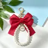 Colgante llavero de lazo de perlas con forma de corazón grande, muñeco de decoración de mochila con cinta colorida estilo Chanel pequeño personalizado